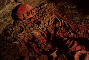 Restos de la supuesta viuda del rey Kinich Yax K’uk’ Mo’, enterrada en una tumba de la fase Margarita del Templo 16. El color rojo se debe al cinabrio con el que ritualmente se pintaron sus huesos.